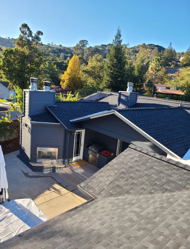 A team of roofers securing new plywood sheathing to the roof trusses