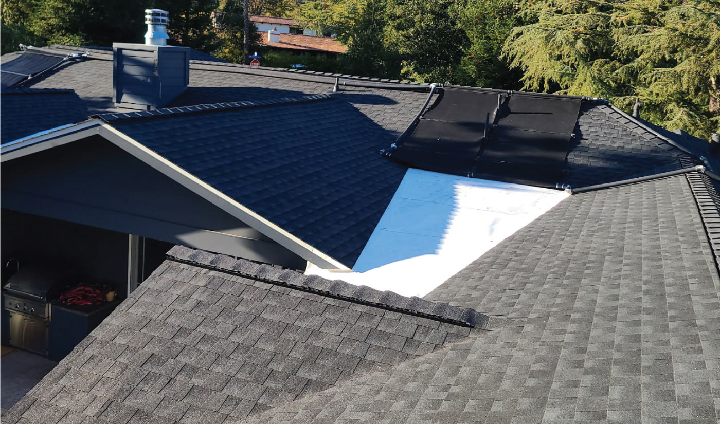 Roofer meticulously aligning ridge cap shingles along the peak of the roof